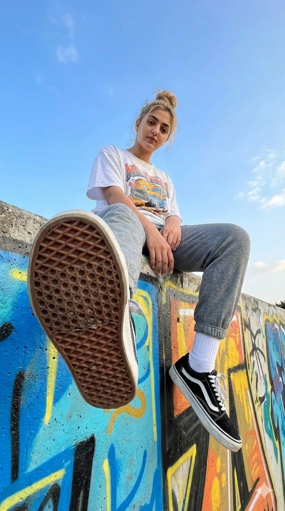 streetwear woman low angle graffiti wall sneaker foreground